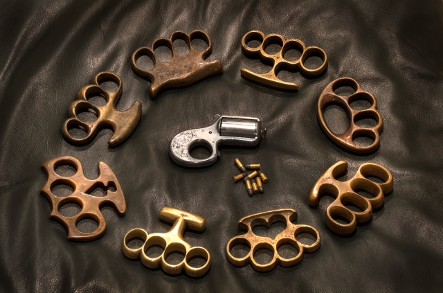 Small caliber handguns like the Knuckle Duster featured in the center were not the only lethal weapons available and commonly carried.  Brass Knuckles could be just as deadly if not more so.